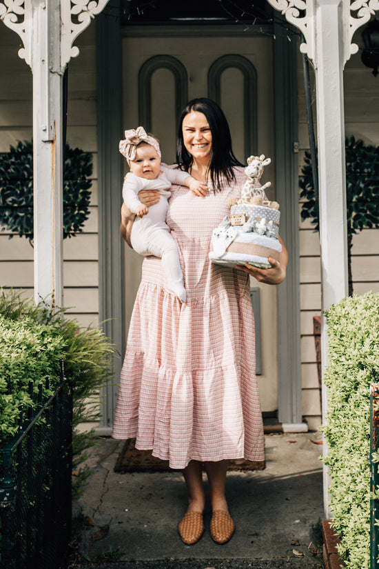 Creative nappy cakes for baby photoshoot styled with rolled nappies ribbons and plush toy