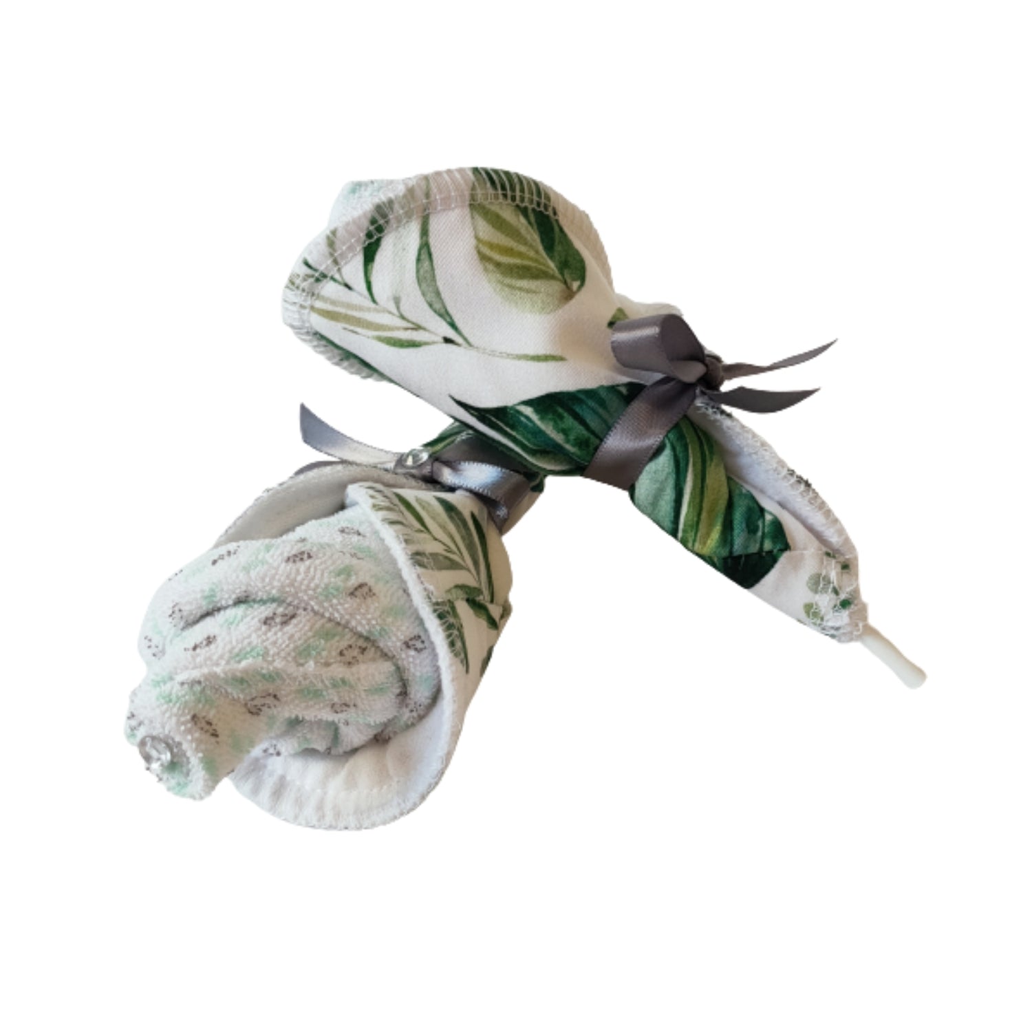 Rolled green leaf print baby nursing pads bundled together with a grey ribbon.