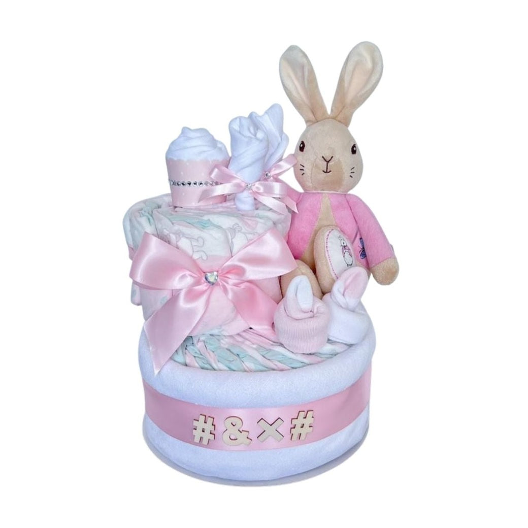 2-Tier Bunny sisnature Nappy Cake featuring a plush bunny, baby socks, cupcake, satin bow premium baby girl gift essentials.