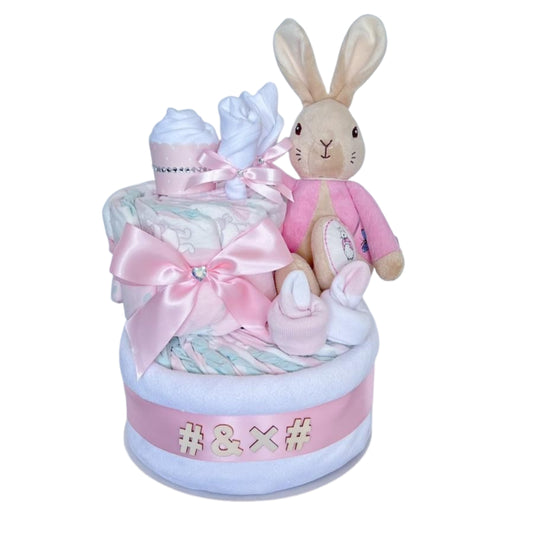 2-Tier Bunny sisnature Nappy Cake featuring a plush bunny, baby socks, cupcake, satin bow premium baby girl gift essentials.