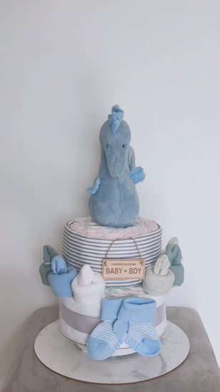 360-degree rotating view of a blue seahorse 1-tier baby boy nappy cake gift set, featuring a plush seahorse toy, receiving blanket, rolled infant nappies, baby booties, and a wooden Congratulations Baby Boy sign.