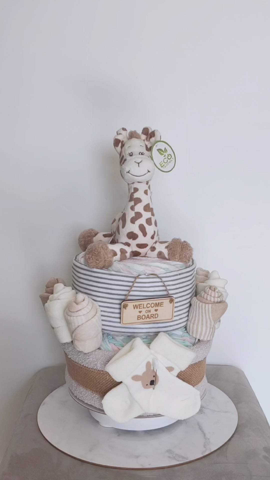 Video of the 2-Tier Giraffe Nappy Cake featuring an eco-friendly plush giraffe, baby socks, premium newborn essentials.