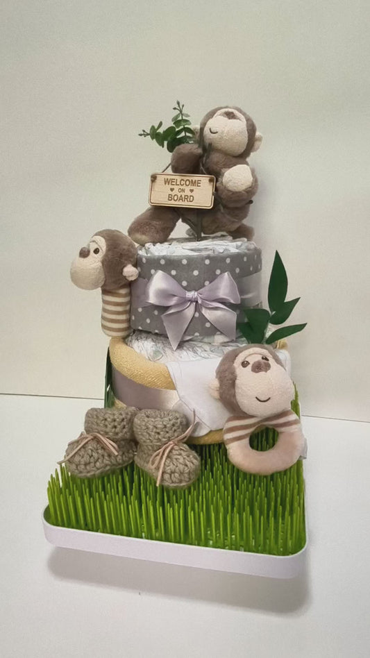 Cheeky monkey welcome nappy cake baby gift with rolled nappies ribbons and plush monkey toy