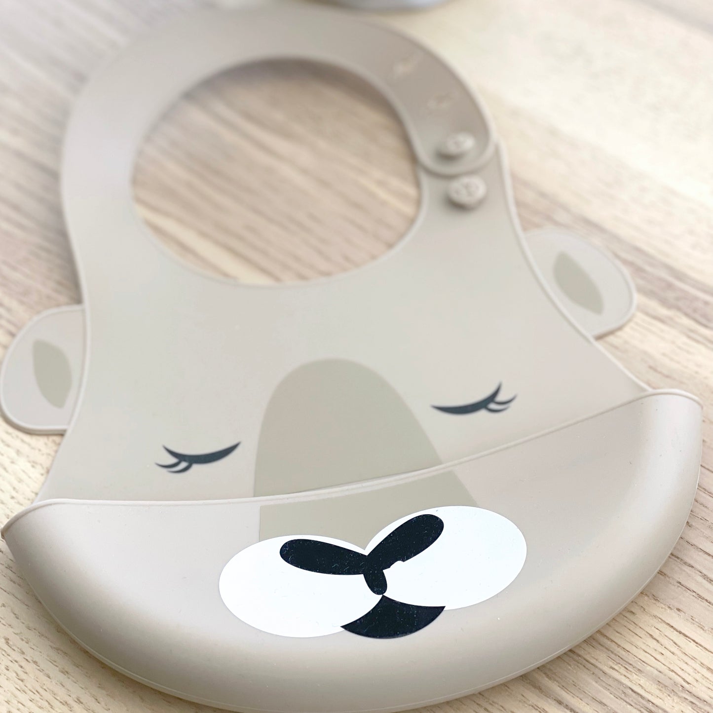 Bubba Blue Australia silicone baby bib with kangaroo design, adjustable neck strap and crumb catcher in taupe.