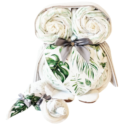 Green leaf pattern owl nappy cake baby gift set featuring rolled nappies, nursing pads, and white baby booties tied with a grey ribbon bow.