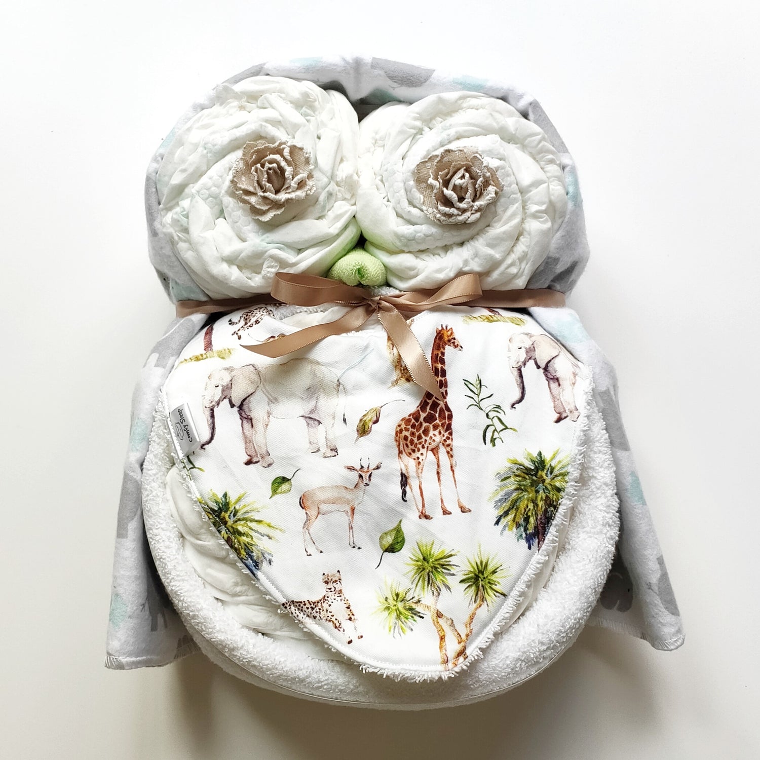 Woodie unisex baby owl nappy cake gift set featuring rolled nappies, Nappy Terry Towel, baby bib, receiving blanket, and a tan ribbon bow.